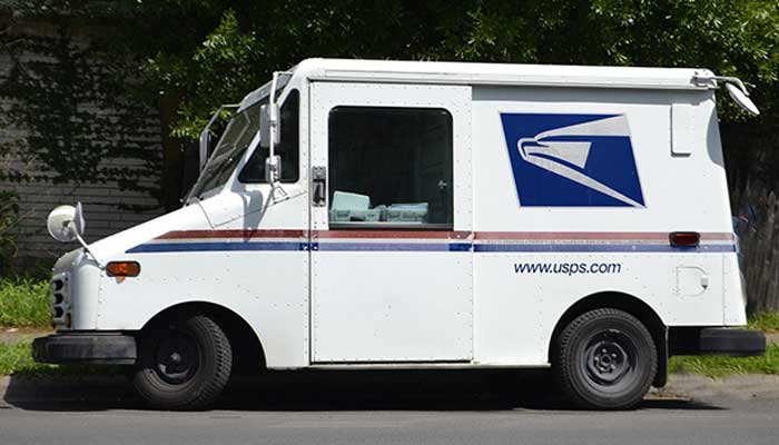United States mail delivery truck parked on side of road.