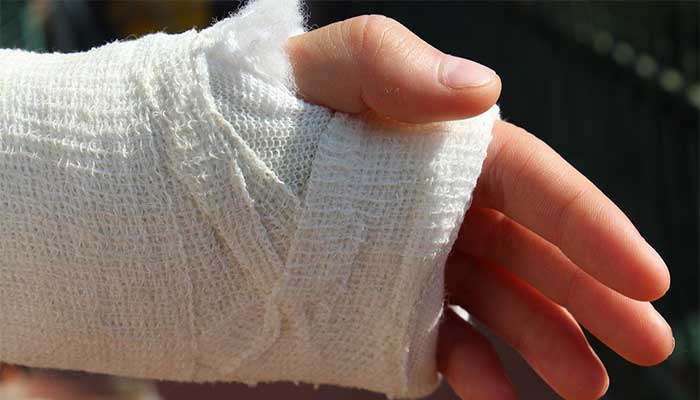 Injured left hand wrapped in gauze bandage.